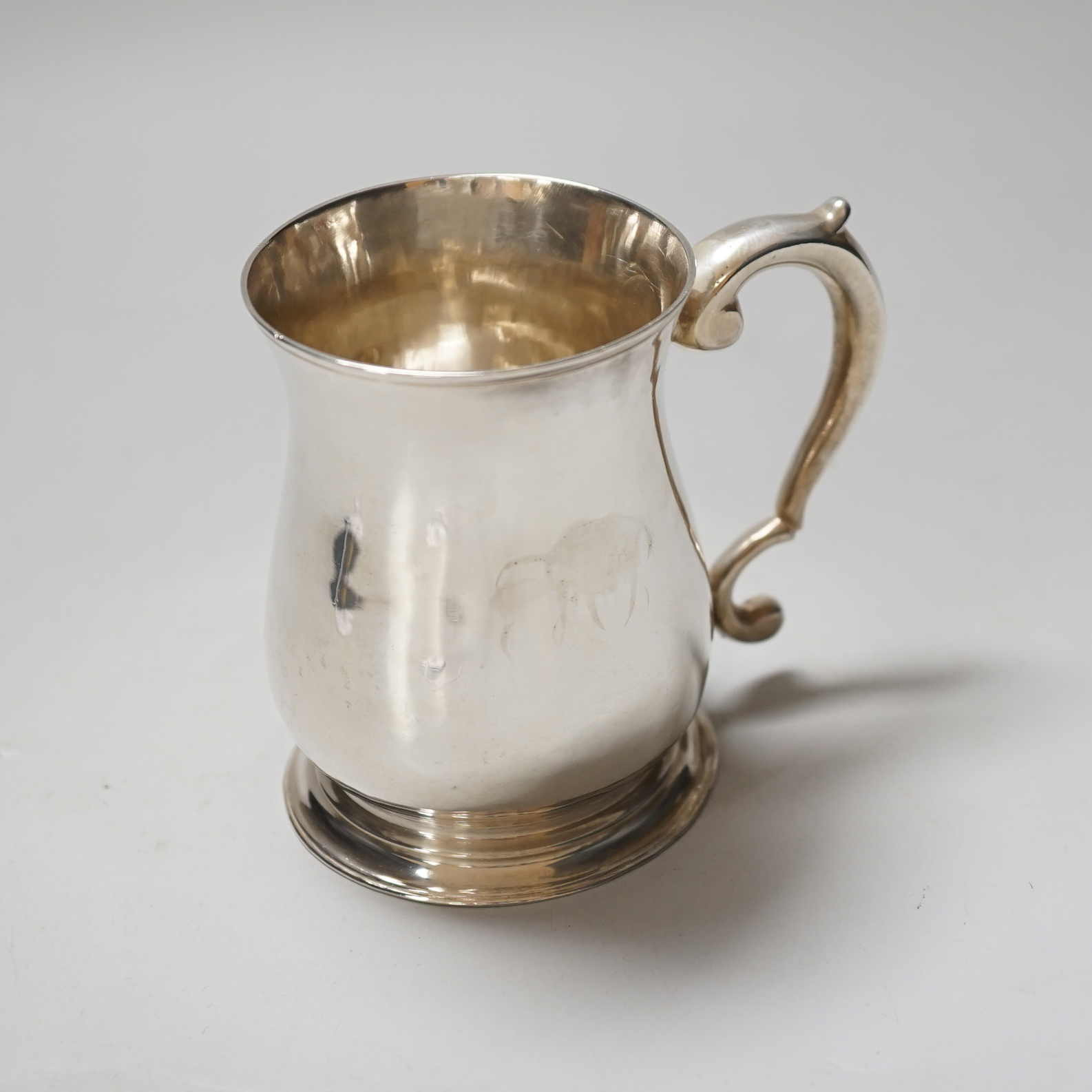 A George II silver baluster mug with scroll handle, makers mark rubbed, London 1752, 9cm, 160 grams